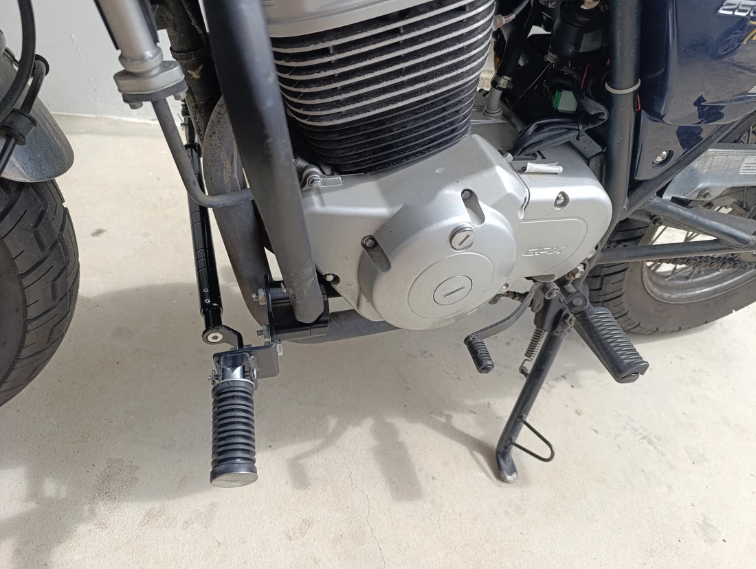 Left-side view of the forward footpeg with the stock footpeg and gear lever still in place