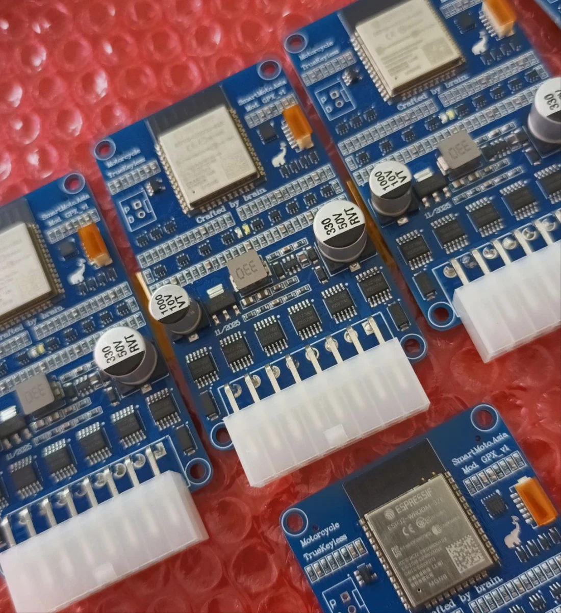 Several assembled TrueKeylessGPX circuit boards with wireless modules and wiring connectors on the workbench