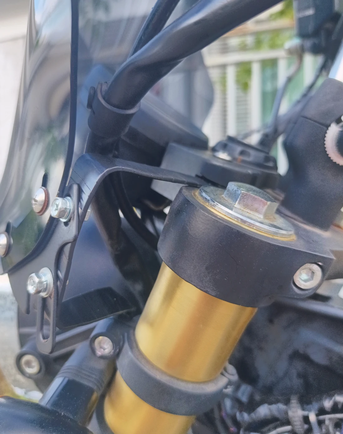 Tape-wrapped upper windscreen bracket running back towards the stock instrument-cluster mounting point
